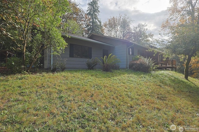 view of side of home with a lawn and a deck