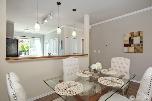dining area with baseboards, ornamental molding, and wood finished floors