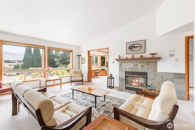 carpeted living room with high vaulted ceiling and a tiled fireplace