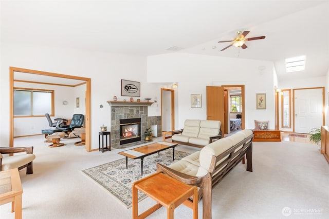 carpeted living room with a fireplace with flush hearth, ceiling fan, and lofted ceiling