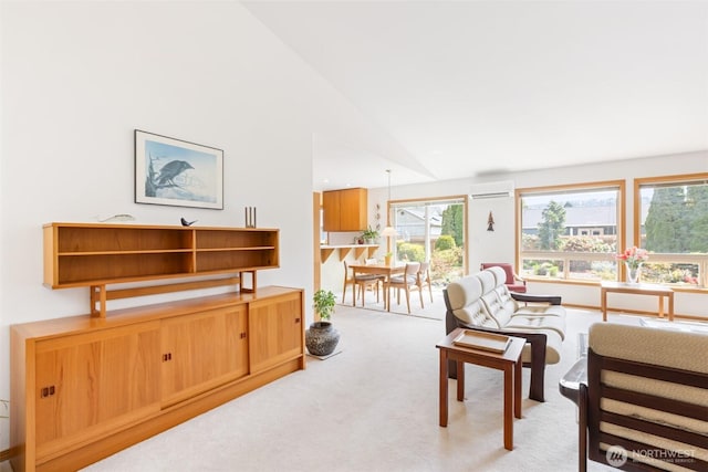 carpeted living area featuring a wall unit AC and vaulted ceiling