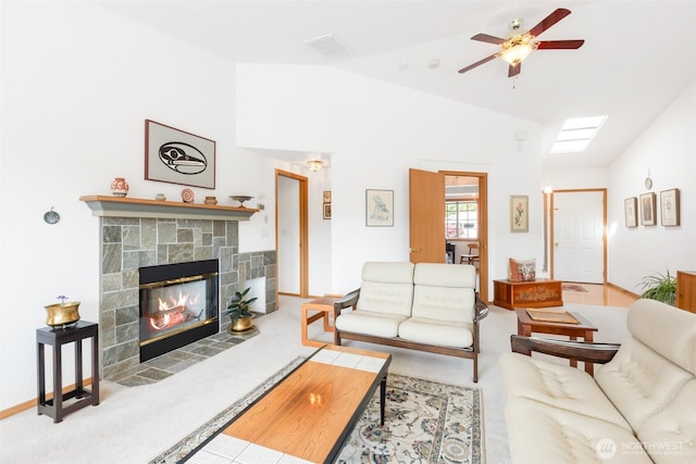 living area with carpet floors, a ceiling fan, a stone fireplace, and lofted ceiling