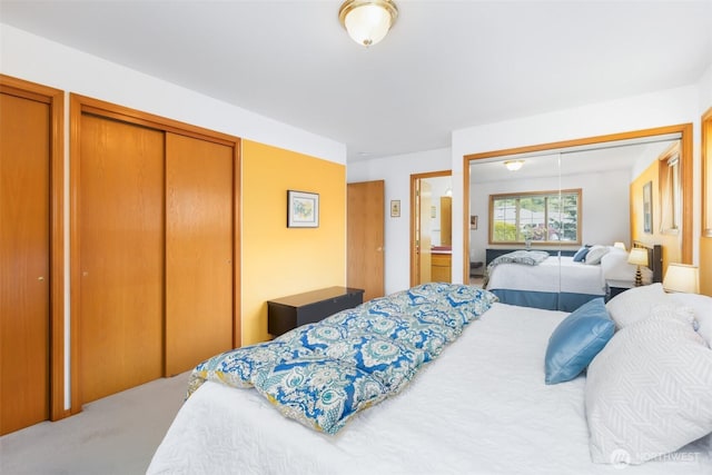bedroom with carpet floors and two closets