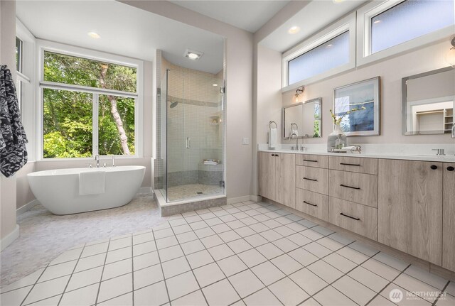 6117 92nd St SW, Mukilteo, WA 98275 - full bathroom featuring a stall shower, double vanity, a soaking tub, baseboards, and tile patterned floors