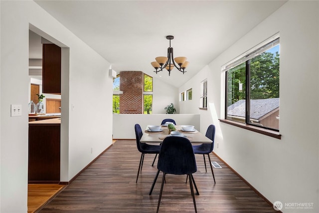 11815 77th Ave S, Seattle, WA 98178 - dining space with a chandelier, vaulted ceiling, dark wood-style floors, and baseboards