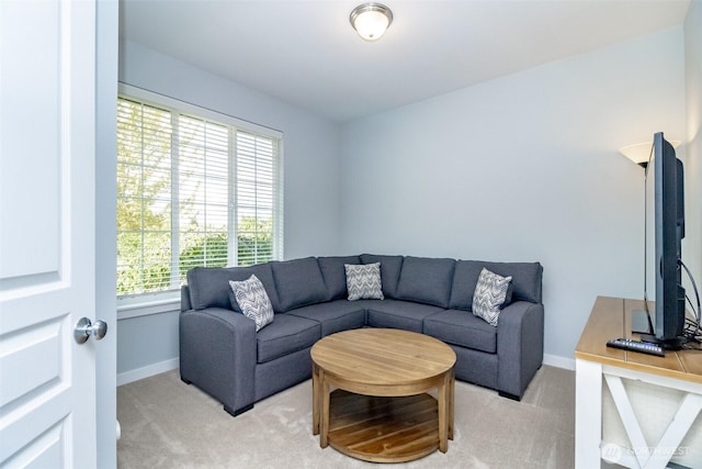 living room featuring light carpet and baseboards