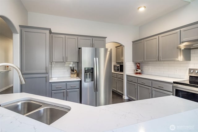 kitchen featuring appliances with stainless steel finishes, gray cabinetry, and a sink