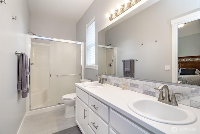 full bathroom with a stall shower, connected bathroom, double vanity, and toilet