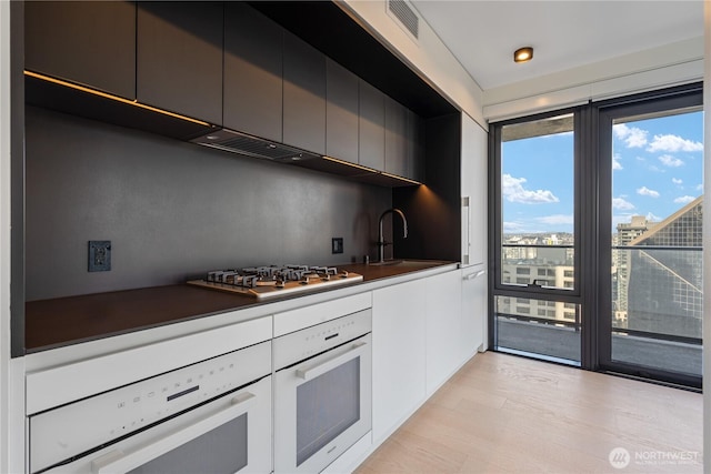 300 Virginia St Unit 2502, Seattle, WA 98101 - kitchen featuring stainless steel gas cooktop, oven, a sink, and modern cabinets