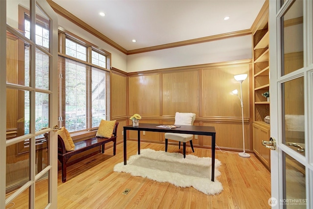 office featuring light wood-type flooring, ornamental molding, and a decorative wall