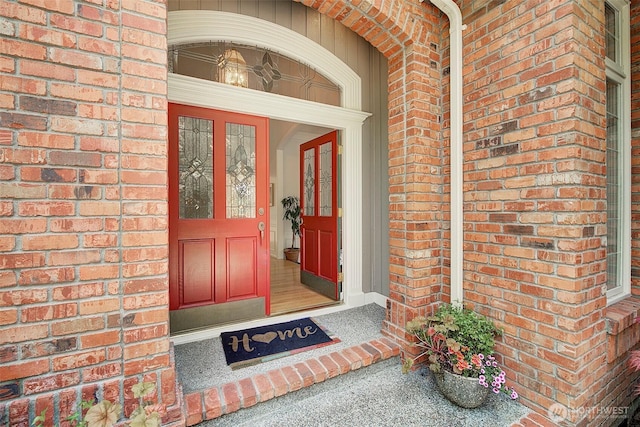 view of exterior entry featuring brick siding