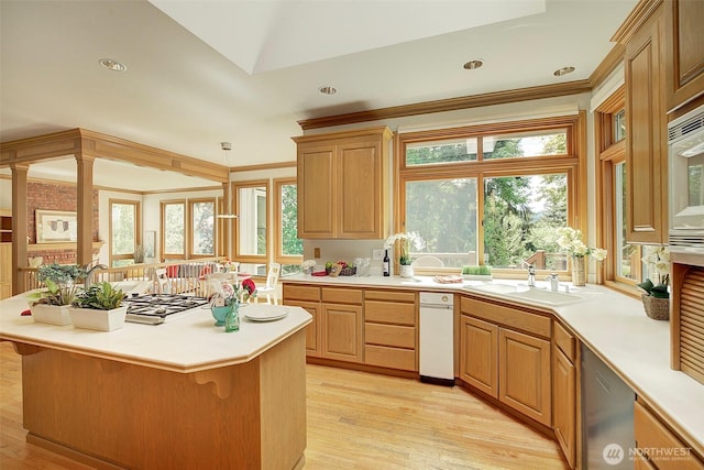 kitchen with a sink, light countertops, a kitchen breakfast bar, and light wood-style floors