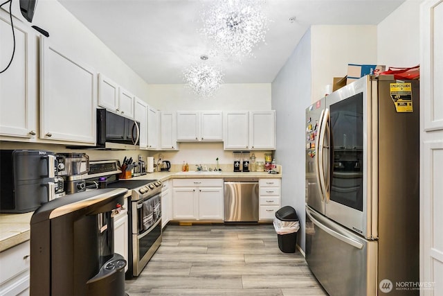 825 Harrington Pl SE Unit 2145, Renton, WA 98058 - kitchen with stainless steel appliances, a chandelier, light countertops, white cabinetry, and light wood-style floors
