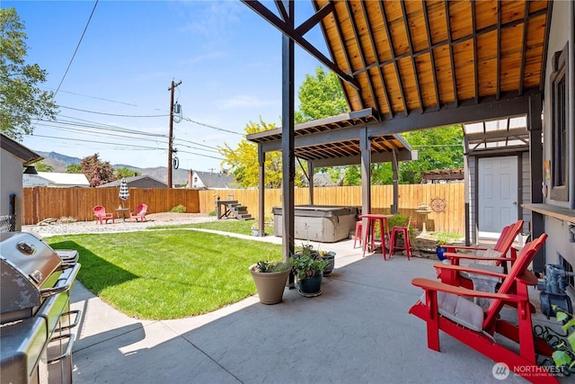 view of patio / terrace with a fenced backyard, a hot tub, and grilling area
