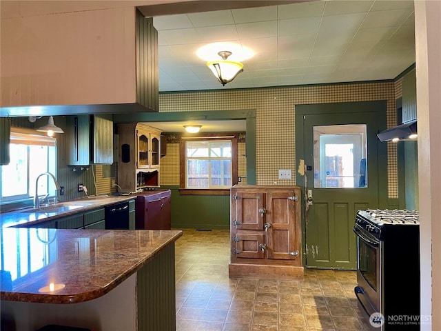 kitchen with stainless steel range with gas cooktop, a sink, dishwasher, and wallpapered walls