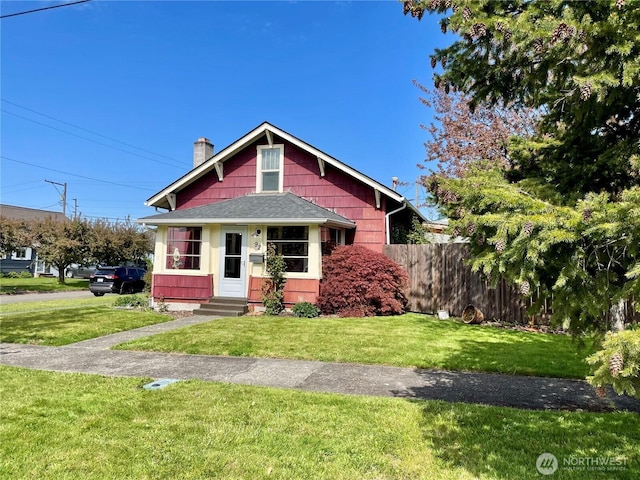 bungalow-style home with fence, a front yard, a chimney, and entry steps