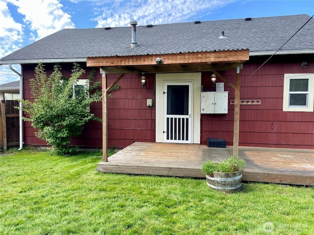 exterior space featuring roof with shingles and a lawn