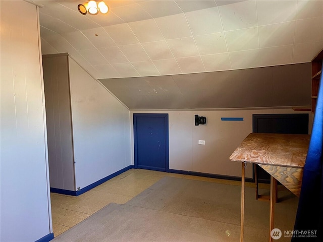 bonus room with baseboards and lofted ceiling