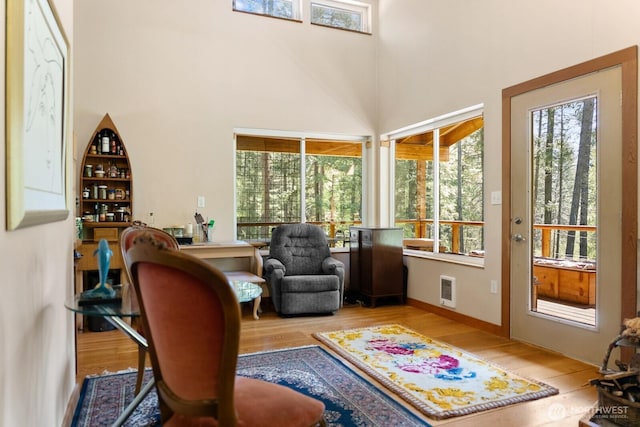 interior space featuring a high ceiling, heating unit, and wood finished floors