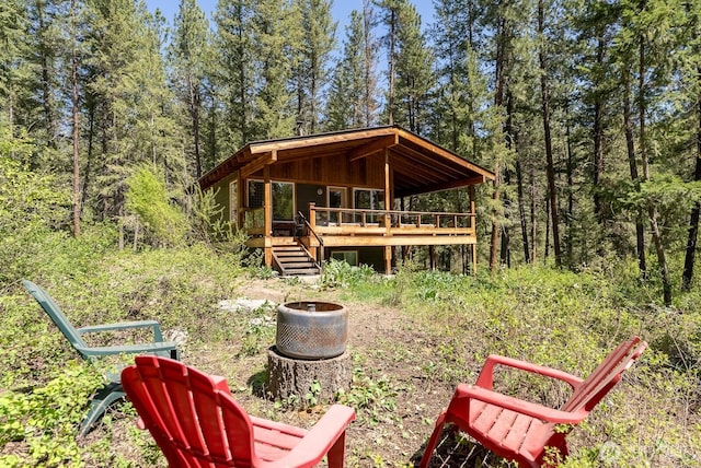 view of yard with a forest view and a wooden deck