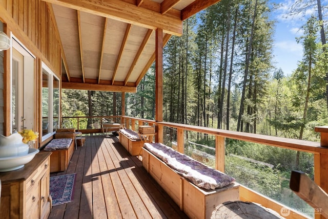 wooden terrace featuring a forest view