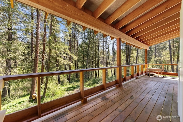 wooden terrace featuring a forest view