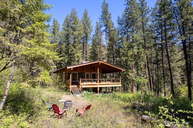 rear view of property with a deck and a wooded view
