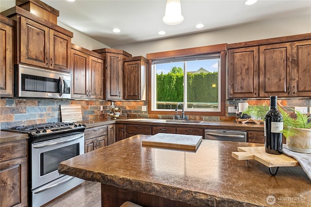 kitchen featuring dark countertops, decorative backsplash, stainless steel appliances, and recessed lighting