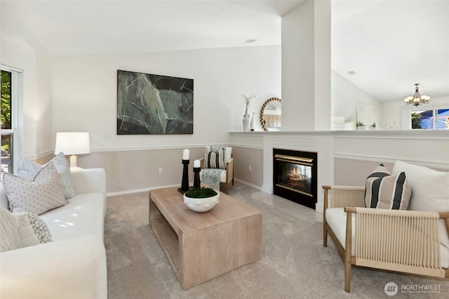 18711 22nd Dr SE, Bothell, WA 98012 - carpeted living room featuring healthy amount of natural light, a chandelier, lofted ceiling, a fireplace with flush hearth, and baseboards