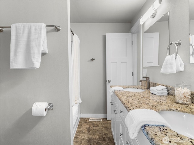 bathroom featuring double vanity, baseboards, and shower / tub combo with curtain