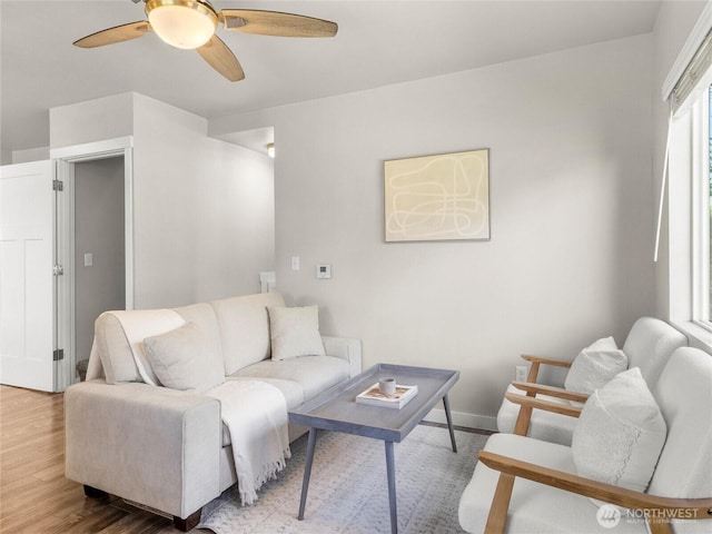 living area with a ceiling fan and wood finished floors