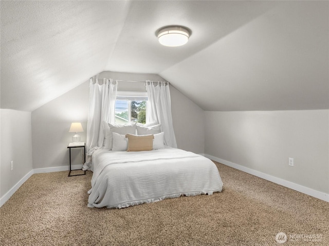 carpeted bedroom with vaulted ceiling and baseboards
