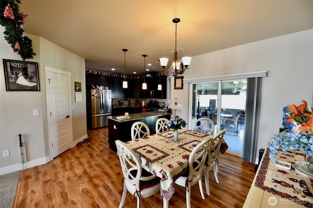 1755 E Madera St, Othello, WA 99344 - dining room with baseboards, a chandelier, and light wood-style flooring