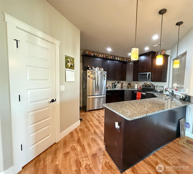 1755 E Madera St, Othello, WA 99344 - kitchen featuring a peninsula, light stone countertops, light wood-style floors, a sink, and stainless steel appliances