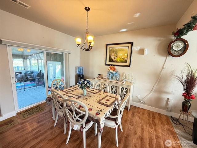 1755 E Madera St, Othello, WA 99344 - dining area featuring visible vents, baseboards, wood finished floors, and a notable chandelier