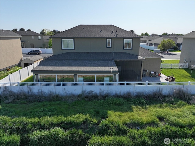1755 E Madera St, Othello, WA 99344 - back of house with a fenced backyard, roof with shingles, a patio area, a lawn, and a residential view