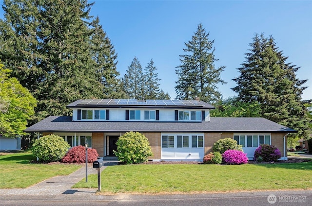 traditional home with solar panels and a front lawn