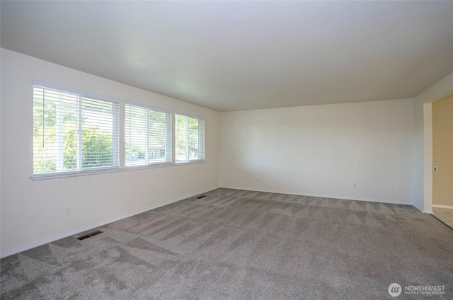 carpeted spare room with baseboards