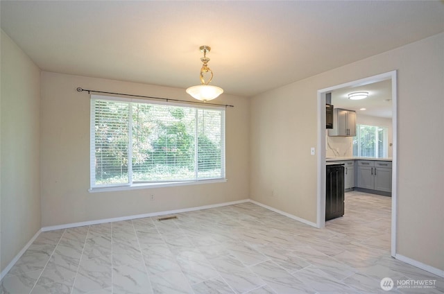 unfurnished dining area with light marble finish floors and baseboards
