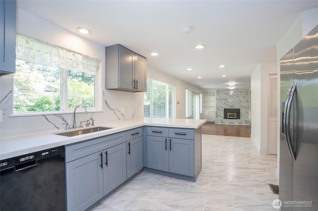 kitchen with stainless steel fridge, black dishwasher, a sink, a peninsula, and recessed lighting