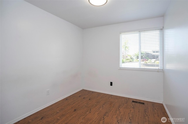 unfurnished room featuring baseboards and wood finished floors