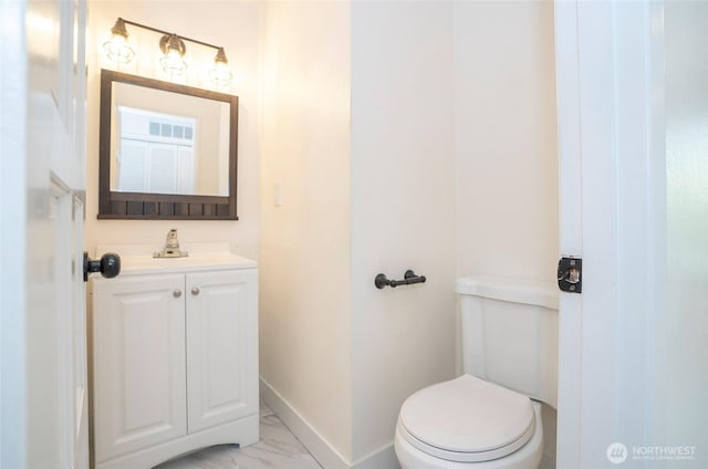 half bath featuring baseboards, marble finish floors, toilet, and vanity