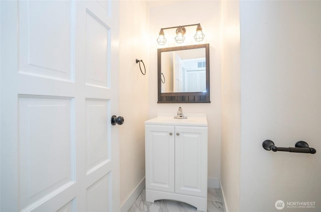bathroom with marble finish flooring, baseboards, and vanity