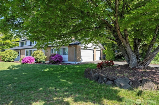 view of green lawn featuring a garage and driveway