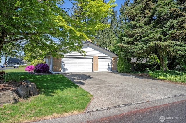 view of front of house with a front lawn, brick siding, and driveway