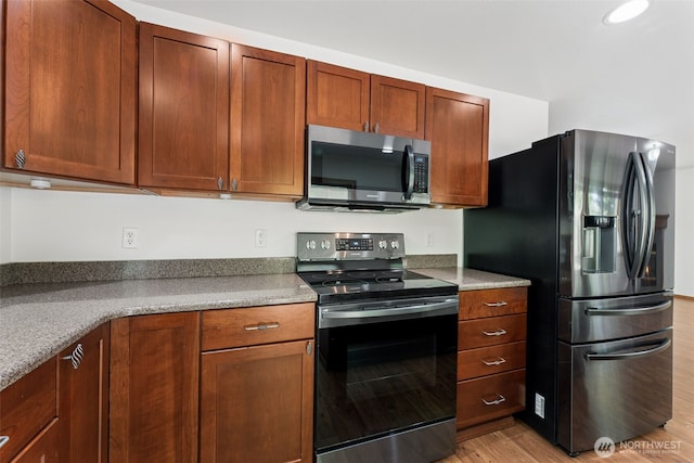 kitchen featuring appliances with stainless steel finishes and light wood finished floors