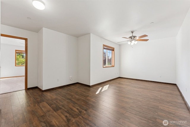 spare room featuring plenty of natural light, ceiling fan, hardwood / wood-style flooring, and baseboards