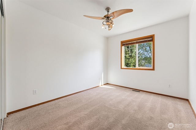 spare room with carpet flooring, a ceiling fan, and baseboards