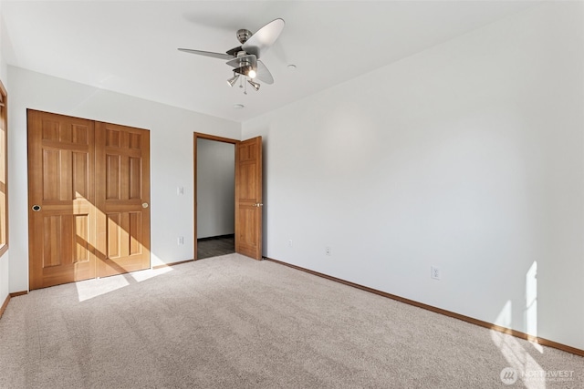 unfurnished bedroom with baseboards, carpet flooring, and ceiling fan