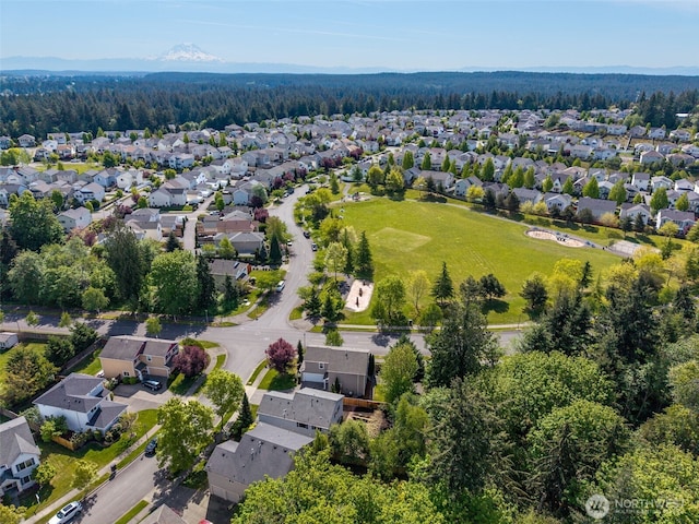 view of property location featuring nearby suburban area and a heavily wooded area